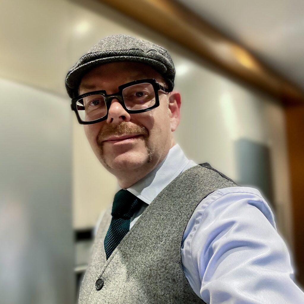 Man i kostym och hatt.