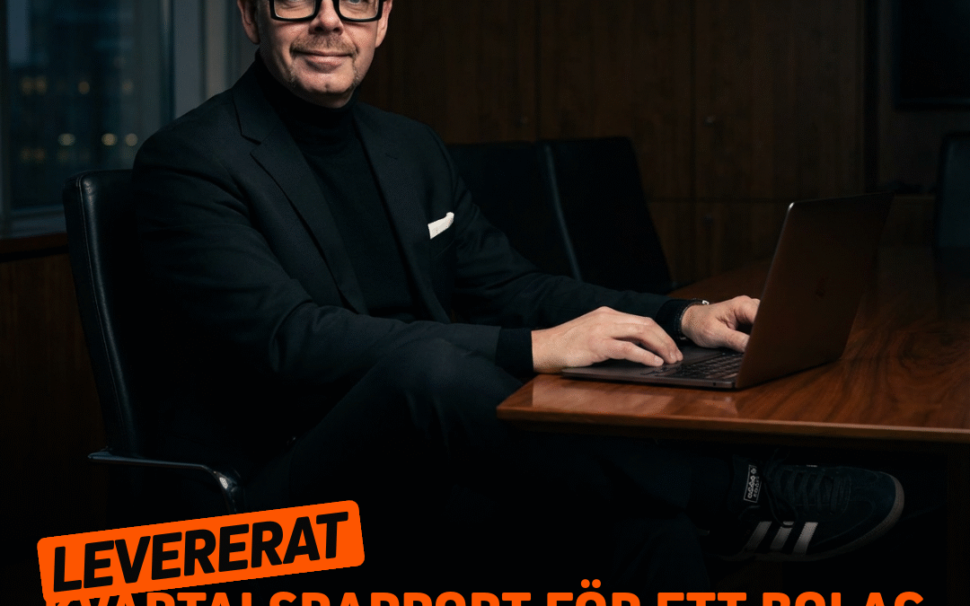 Man i svart kostym och glasögon som arbetar vid en laptop i en modern kontorsmiljö.